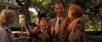 Movie still from “Tucker: The Man and His Dream” (1988), directed by Francis Ford Coppola – A group of people standing next to each other in a park; Medium shot, Low angle