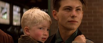 Movie still from “Tucker: The Man and His Dream” (1988), directed by Francis Ford Coppola – A man and a boy are looking at the camera; Close Up shot, Low angle