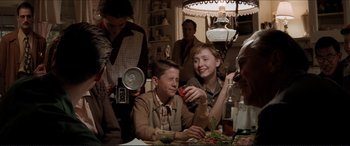 Movie still from “Tucker: The Man and His Dream” (1988), directed by Francis Ford Coppola – A group of people sitting at a table with food; Medium shot, Over the shoulder angle