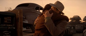 Movie still from “Tucker: The Man and His Dream” (1988), directed by Francis Ford Coppola – A man and a woman hugging in front of a car; Medium shot, Low angle