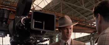 Movie still from “Tucker: The Man and His Dream” (1988), directed by Francis Ford Coppola – A man wearing a hat standing in front of a video camera; Close Up shot, Low angle