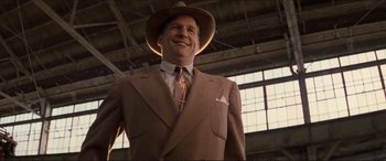 Movie still from “Tucker: The Man and His Dream” (1988), directed by Francis Ford Coppola – A man in a suit and hat smiling for the camera; Medium shot, Low angle