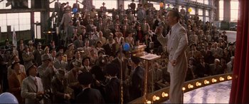 Movie still from “Tucker: The Man and His Dream” (1988), directed by Francis Ford Coppola – A crowd of people sitting and standing in front of a microphone; Wide shot, High angle