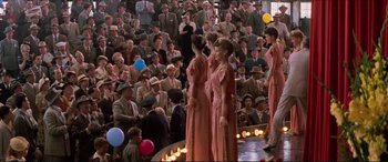 Movie still from “Tucker: The Man and His Dream” (1988), directed by Francis Ford Coppola – A group of women standing in front of an audience; Wide shot, High angle