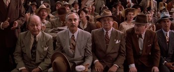Movie still from “Tucker: The Man and His Dream” (1988), directed by Francis Ford Coppola – A group of men sitting next to each other in suits; Medium shot, Low angle