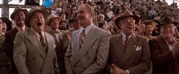 Movie still from “Tucker: The Man and His Dream” (1988), directed by Francis Ford Coppola – A group of men in suits and hats in front of a crowd; Medium shot, Low angle