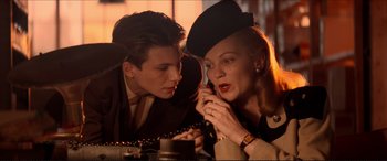 Movie still from “Tucker: The Man and His Dream” (1988), directed by Francis Ford Coppola – A man and a woman looking at a cell phone; Medium shot, Low angle