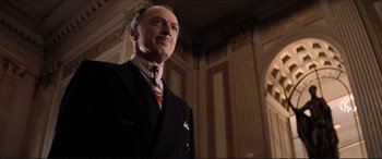 Movie still from “Tucker: The Man and His Dream” (1988), directed by Francis Ford Coppola – An older man wearing a suit and tie in a room; Medium shot, Low angle