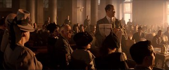 Movie still from “Tucker: The Man and His Dream” (1988), directed by Francis Ford Coppola – An old man is speaking to a group of people; Wide shot, Low angle