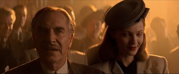 Movie still from “Tucker: The Man and His Dream” (1988), directed by Francis Ford Coppola – An older man and a young woman are sitting together; Close Up shot, Low angle