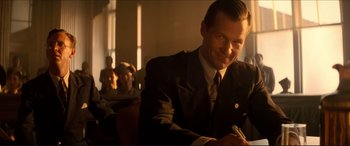 Movie still from “Tucker: The Man and His Dream” (1988), directed by Francis Ford Coppola – A man in a suit sitting in front of other people; Close Up shot, Low angle