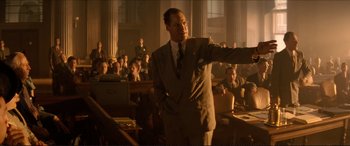 Movie still from “Tucker: The Man and His Dream” (1988), directed by Francis Ford Coppola – A man in a suit and tie in front of an audience; Medium shot, Low angle