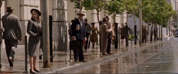 Movie still from “Tucker: The Man and His Dream” (1988), directed by Francis Ford Coppola – A group of men standing on the sidewalk in the rain; Wide shot, High angle