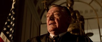 Movie still from “Tucker: The Man and His Dream” (1988), directed by Francis Ford Coppola – An older man in a suit and tie looking up; Close Up shot, Low angle