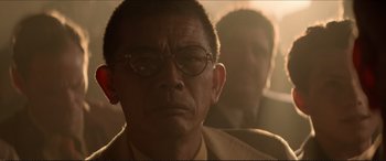 Movie still from “Tucker: The Man and His Dream” (1988), directed by Francis Ford Coppola – An older man wearing glasses sitting next to another man; Close Up shot, Low angle