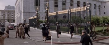 Movie still from “Tucker: The Man and His Dream” (1988), directed by Francis Ford Coppola – A group of people walking down a sidewalk near a building; Extreme Wide shot, High angle