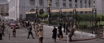 Movie still from “Tucker: The Man and His Dream” (1988), directed by Francis Ford Coppola – A group of people walking down a sidewalk near a building; Extreme Wide shot, High angle