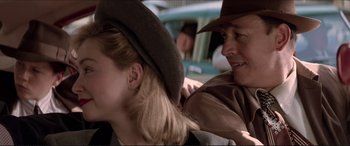 Movie still from “Tucker: The Man and His Dream” (1988), directed by Francis Ford Coppola – A man and a woman wearing a hat and smiling; Close Up shot, Over the shoulder angle