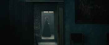 Movie still from “Tulip Fever” (2017), directed by Justin Chadwick – A woman dressed in period clothing standing in a doorway; Wide shot, Over the shoulder angle