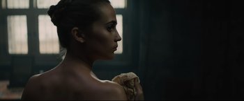 Movie still from “Tulip Fever” (2017), directed by Justin Chadwick – A beautiful woman holding a snake in a dark room; Close Up shot, Low angle