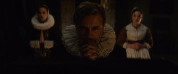 Movie still from “Tulip Fever” (2017), directed by Justin Chadwick – A man with a beard is wearing a ruff and praying; Close Up shot, Over the shoulder angle