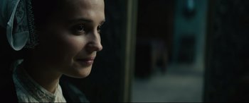 Movie still from “Tulip Fever” (2017), directed by Justin Chadwick – A woman's face in a dark room; Close Up shot, Over the shoulder angle