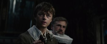 Movie still from “Tulip Fever” (2017), directed by Justin Chadwick – A young man and an older man are standing together; Close Up shot, Over the shoulder angle