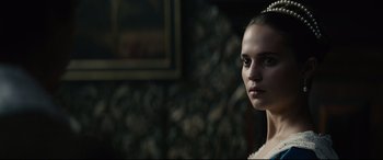 Movie still from “Tulip Fever” (2017), directed by Justin Chadwick – A young woman in a white dress is looking at the camera; Close Up shot, Over the shoulder angle