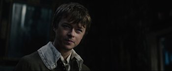 Movie still from “Tulip Fever” (2017), directed by Justin Chadwick – A young man with short brown hair wearing a brown jacket; Close Up shot, Over the shoulder angle