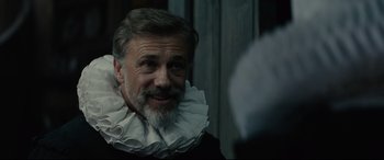 Movie still from “Tulip Fever” (2017), directed by Justin Chadwick – A man with a beard wearing a white ruffle around his neck; Close Up shot, Over the shoulder angle
