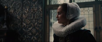 Movie still from “Tulip Fever” (2017), directed by Justin Chadwick – A woman wearing a white elizabethan style ruff; Close Up shot, Over the shoulder angle