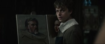 A man standing in front of a painting of a woman