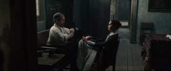 Movie still from “Tulip Fever” (2017), directed by Justin Chadwick – A man and a woman sitting in a chair; Medium shot, High angle