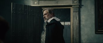 Movie still from “Tulip Fever” (2017), directed by Justin Chadwick – A man with a long beard wearing a black coat; Medium shot, Over the shoulder angle
