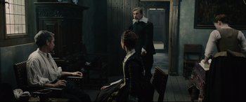 Movie still from “Tulip Fever” (2017), directed by Justin Chadwick – A man and a woman standing in front of a door; Wide shot, Over the shoulder angle