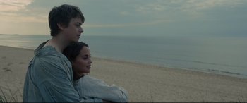 Movie still from “Tulip Fever” (2017), directed by Justin Chadwick – A man and a woman sitting next to each other on the beach; Close Up shot, High angle