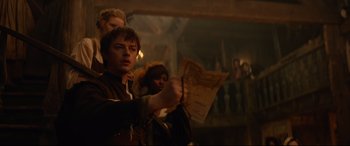 Movie still from “Tulip Fever” (2017), directed by Justin Chadwick – A group of people standing in a dimly - lit room; Medium shot, Low angle