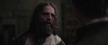 Movie still from “Tulip Fever” (2017), directed by Justin Chadwick – A man with long hair and a beard looking to his left; Close Up shot, Over the shoulder angle