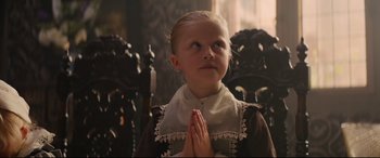 Movie still from “Tulip Fever” (2017), directed by Justin Chadwick – A little girl with her hands clasped in front of her face; Close Up shot, Low angle
