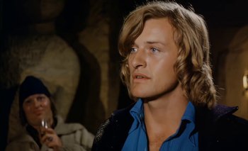 Movie still from “Turkish Delight” (1973), directed by Paul Verhoeven – A man with blonde hair and a blue shirt; Close Up shot, Over the shoulder angle