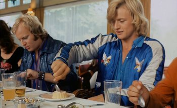 Movie still from “Turkish Delight” (1973), directed by Paul Verhoeven – A man is cutting a piece of cake at a table; Medium shot, Low angle