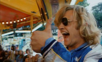 Movie still from “Turkish Delight” (1973), directed by Paul Verhoeven – A man with blonde hair and sunglasses giving a thumbs up; Medium shot, Low angle