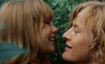 Movie still from “Turkish Delight” (1973), directed by Paul Verhoeven – Two women smiling and touching each other's faces; Close Up shot, Overhead angle