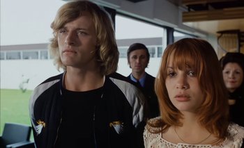 Movie still from “Turkish Delight” (1973), directed by Paul Verhoeven – A group of people standing next to each other in a room; Medium shot, Low angle