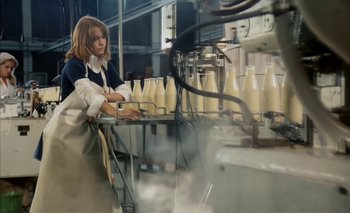 Movie still from “Turkish Delight” (1973), directed by Paul Verhoeven – A woman working in a factory with a bunch of milk bottles; Medium shot, High angle