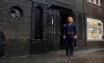 Movie still from “Turkish Delight” (1973), directed by Paul Verhoeven – A man standing in front of an iron gate; Wide shot, Low angle
