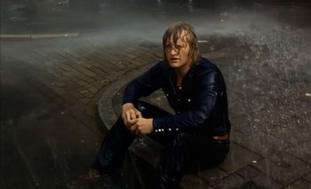 Movie still from “Turkish Delight” (1973), directed by Paul Verhoeven – A man sitting on the ground in the rain; Medium shot, Low angle