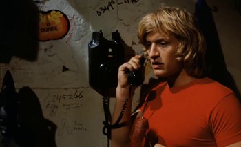 Movie still from “Turkish Delight” (1973), directed by Paul Verhoeven – A man talking on a phone in a room with graffiti on the walls; Close Up shot, Low angle