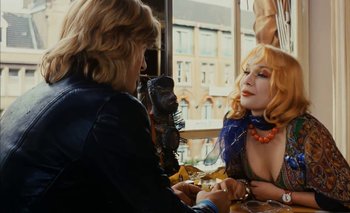Movie still from “Turkish Delight” (1973), directed by Paul Verhoeven – A woman sitting at a table talking to another woman; Medium shot, Over the shoulder angle