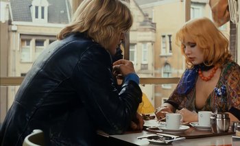 Movie still from “Turkish Delight” (1973), directed by Paul Verhoeven – Two people sitting at a table with a cup of coffee; Medium shot, Over the shoulder angle